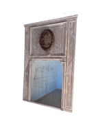 1800s French trumeau mirror in original weathered gray paint, with a carved oval profile medallion above a foxed mirror plate