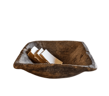 18th century deep walnut wood dough bowl with a rough-hewn interior, angular pinched ends, and a dark aged patina