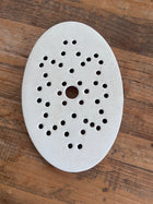 Antique Belgian ironstone oval strainer with star-pattern perforations displayed on a wood surface