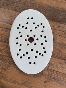 Antique Belgian ironstone oval strainer with star-pattern perforations displayed on a wood surface