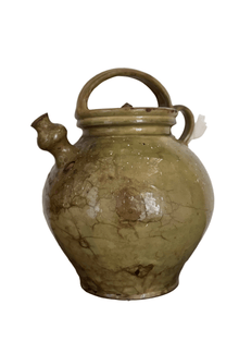 Antique French walnut oil jug with a domed lid, arched handle, and side spout, in a heavily crackled pale green glaze