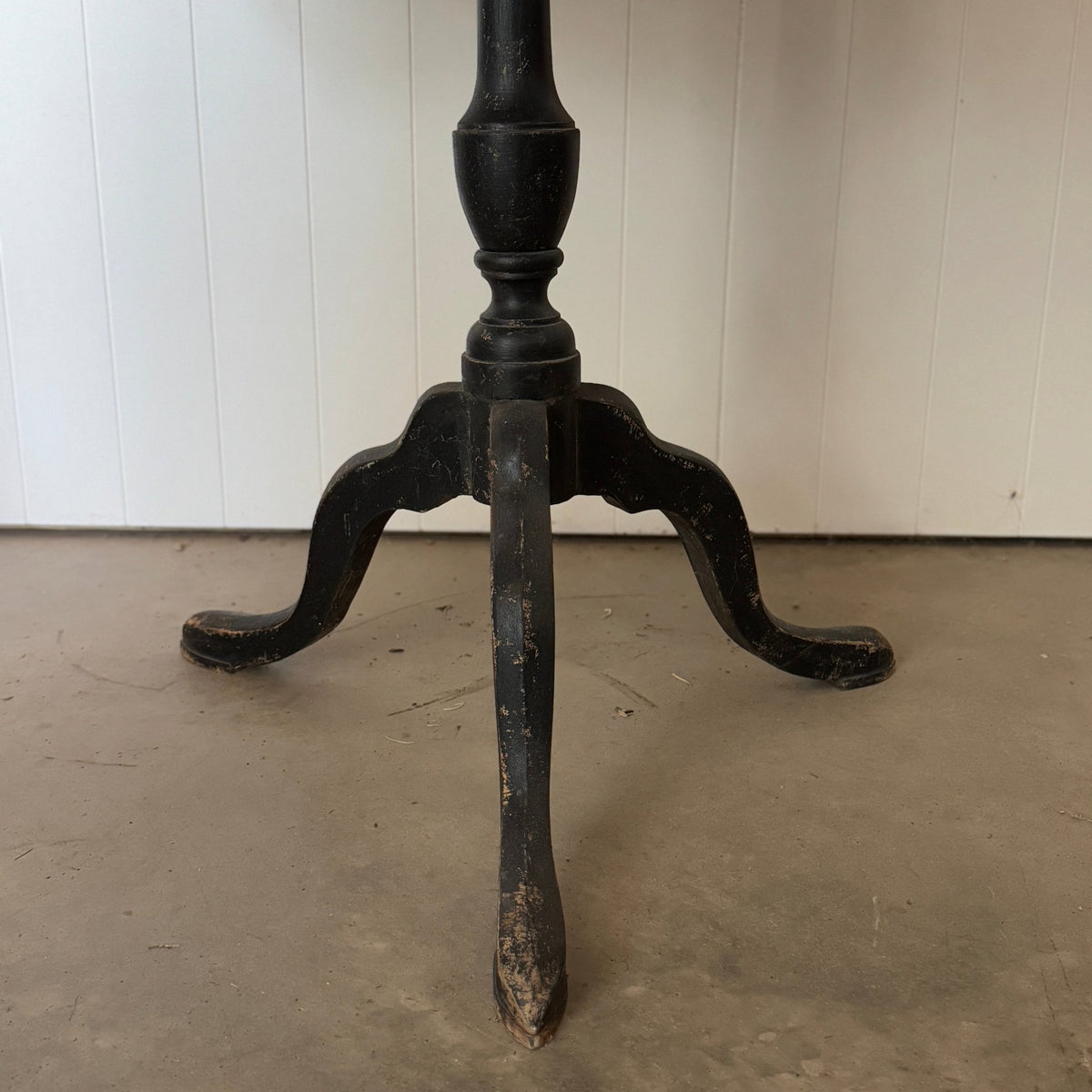 Close-up low angle view of the black cabriole tripod base and legs