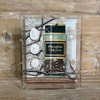 Angled view of the framed shadowbox showing the acrylic case edge, painted apothecary jar, and cameo medallions