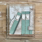 Framed shadowbox with painted book spines and cast plaster intaglio medallions mounted on toile fabric