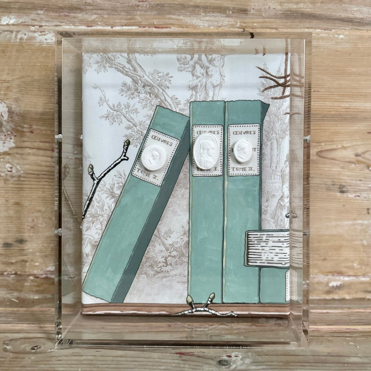 Framed shadowbox with painted book spines and cast plaster intaglio medallions mounted on toile fabric