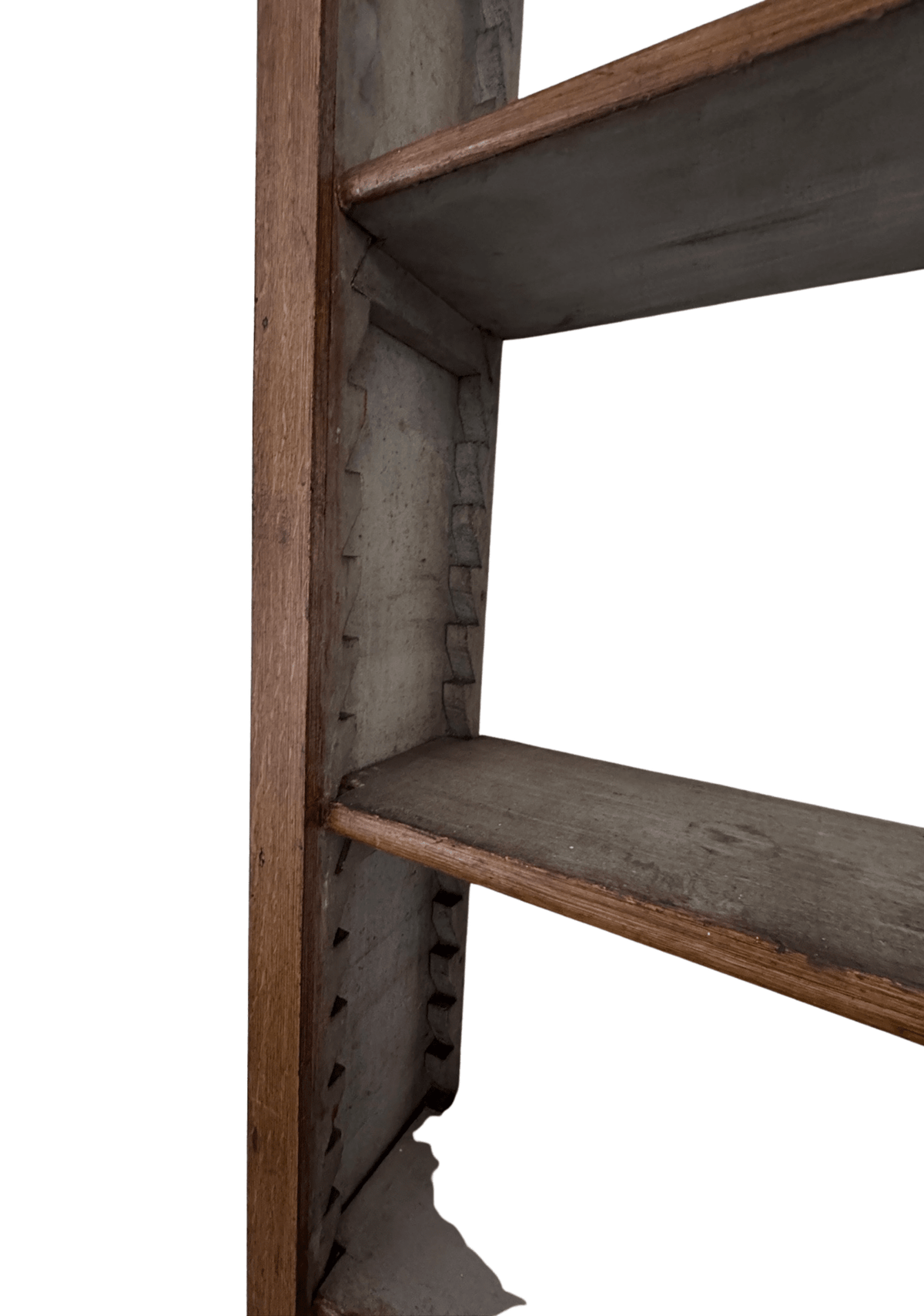 Close-up of the bookcase's interior side rail showing the notched shelf-support pins and gray-toned faux bois graining