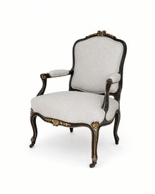 Louis XV-style armchair, black-painted with gilt floral carving and cabriole legs, upholstered in white and black pinstripe fabric