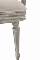 Close-up of the swivel chair's fluted leg and molded seat rail, showing distressed gray paint with worn edges